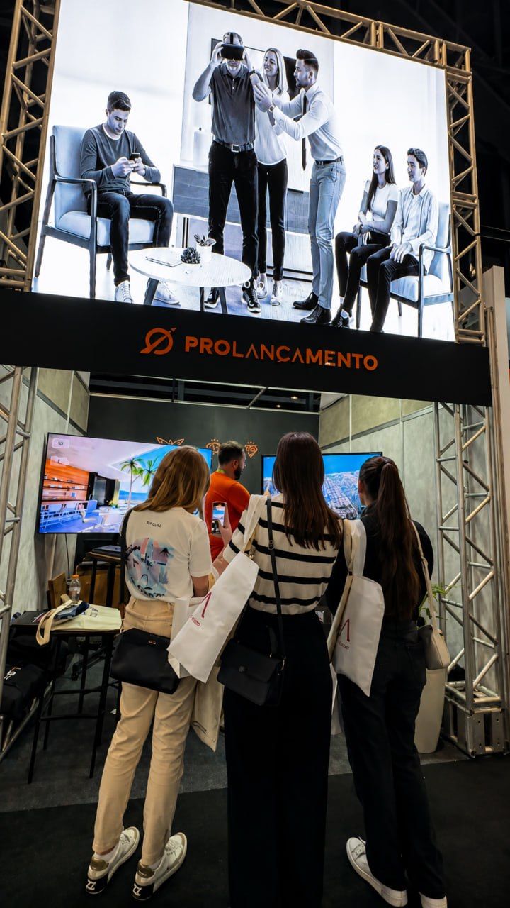 Visitantes conhecendo a gamificação imobiliária no stand da Pró Lançamento